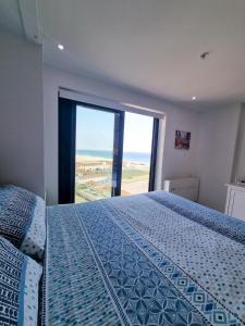 a bedroom with a bed and a large window at Brand New Top Floor Studio - The Hub Gibraltar - Self Catering in Gibraltar