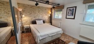 a bedroom with a bed and a brick wall at ApartHotel SAVAS 3 Studio and parking in Kaunas +25 photos