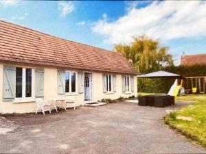 uma casa com duas cadeiras e uma tenda em frente em Maison de vacance em Cabourg