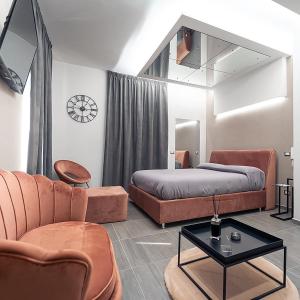 a bedroom with a bed and a couch and a table at Intimity Luxury Rooms in Qualiano