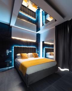 a bedroom with a large bed with a yellow blanket at Intimity Luxury Rooms in Qualiano