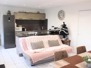 uma sala de estar com um sofá e uma cozinha em Maison de vacance em Cabourg