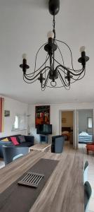 a living room with a chandelier hanging from the ceiling at La Ginelle - Appartement Isba in Airoux
