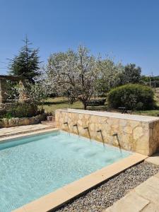 una piscina con una pared de piedra alrededor en Cal Colina - Karaktervol landhuis met privé zwembad en Pacs del Penedes