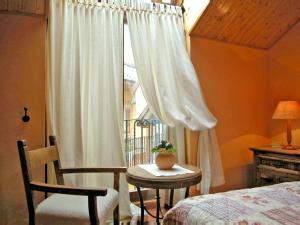 een slaapkamer met een bed, een tafel en een raam bij Casas rurales Valle de El Paular in Rascafría