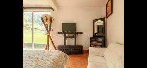 a bedroom with a bed and a mirror and a tv at Hotel Rancho el Paraíso in Valle de Bravo