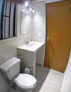 a bathroom with a toilet and a sink at El Depa del Puerto in Cancún