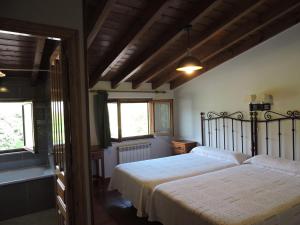 a bedroom with two beds and two windows at Casa Pancho Porrúa in Porrúa