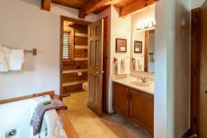 a bathroom with a sink and a toilet and a mirror at Wolf Run Gatlinburg Location Log Cabin Hot Tub in Gatlinburg