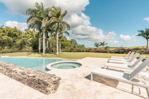 a patio with chairs and a swimming pool at Golf View Apt at Casa De Campo in Buena Vista