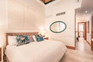 sypialnia z białym łóżkiem i lustrem w obiekcie Golf View Apt at Casa De Campo w mieście Buena Vista