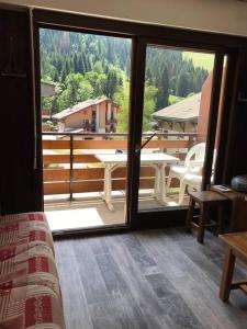 Habitación con vistas a un balcón con mesa. en La montagne « un coin d’oxygène », en Châtel