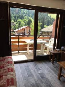 a room with a view of a balcony with a table at La montagne « un coin d’oxygène » in Châtel