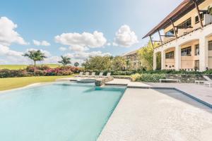 a swimming pool in front of a building at Golf View Apt at Casa De Campo in Buena Vista