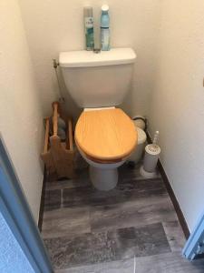 a toilet with a wooden seat in a bathroom at La montagne « un coin d’oxygène » in Châtel