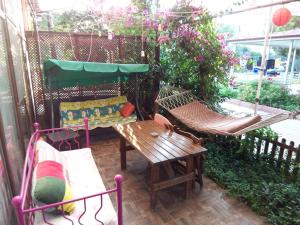 un patio con 2 hamacas, una mesa y un banco en izmir Tatil Evi Beach Resort Seferihisar en Ürkmez
