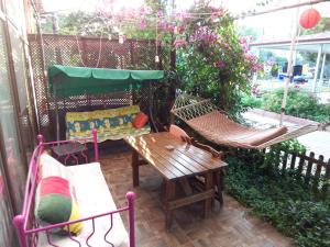 a patio with two hammocks and a table and a bench at izmir Tatil Evi Beach Resort Seferihisar in Ürkmez