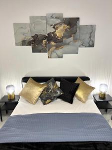 um quarto com uma cama com quatro pinturas na parede em FELLINI SUITES Lungomare near the sea em Catânia