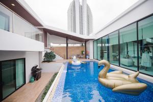 a swimming pool with swans in a building at Movenpick Pool Villa by Hello Pattaya in Na Jomtien