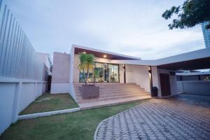 a house with a palm tree in the front of it at Movenpick Pool Villa by Hello Pattaya in Na Jomtien