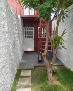 un árbol frente a un edificio con una puerta en Container LB CAXU, en Boa Vista 1 foto más