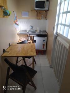 una pequeña cocina con una mesa de madera en una habitación en Container LB CAXU en Boa Vista