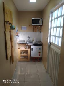Una pequeña cocina con fregadero y microondas. en Container LB CAXU, en Boa Vista