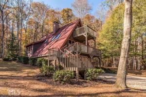 una casa con techo de gambrel con escaleras a una casa en Farmhouse in a Peaceful Paradise with Huge Hot tub, en Gainesville