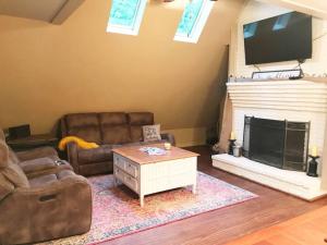 a living room with two couches and a fireplace at Farmhouse in a Peaceful Paradise with Huge Hot tub in Gainesville