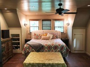 1 dormitorio con 1 cama y ventilador de techo en Farmhouse in a Peaceful Paradise with Huge Hot tub, en Gainesville