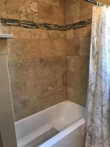 a bathroom with a bath tub with a shower curtain at Farmhouse in a Peaceful Paradise with Huge Hot tub in Gainesville +31 photos