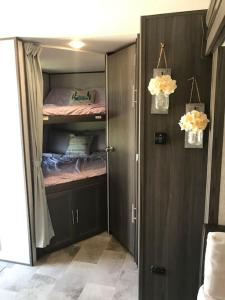 a bedroom with a closet with wooden cabinets and a bed at Happys Camper in the Sunshine in Daytona Beach