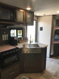 a kitchen with a sink and a stove at Happys Camper in the Sunshine in Daytona Beach