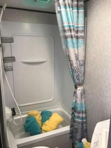 a small room with a shower curtain and towels at Happys Camper in the Sunshine in Daytona Beach