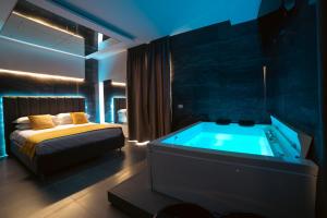 a bedroom with a bed and a tub in it at Intimity Luxury Rooms in Qualiano