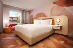 a bedroom with a large bed with a painting on the wall at MGM Grand in Las Vegas
