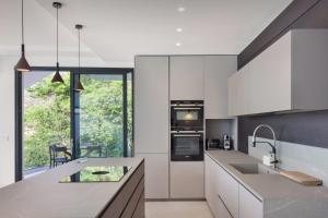 a kitchen with white cabinets and a large window at Residenza Dimora Privata With Pool in Malcesine