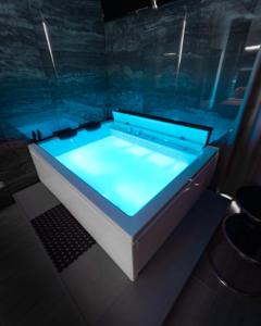 a hot tub with blue lighting in a room at Intimity Luxury Rooms in Qualiano
