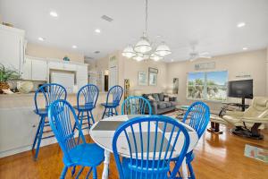 a dining room with blue chairs and a table at Seaside Serenity Direct Oceanfront in Ormond Beach