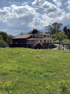 Casa Pancho Porrúa في Porrúa: منزل على حقل من العشب الأخضر مع مبنى