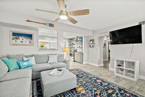 a living room with a couch and a flat screen tv at The Blue Anchor Cottage in Daytona Beach