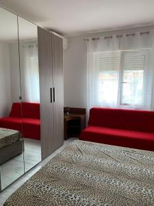 uma sala de estar com um sofá vermelho e um espelho em Appartamento SanBart Mare em San Bartolomeo al Mare