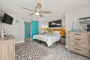 een slaapkamer met een bed en een plafondventilator bij The Blue Anchor Cottage in Daytona Beach