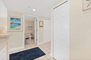 a white door in a bathroom with a toilet at Sunshine Beach Condo with Balcony Pool Hot Tub in Daytona Beach