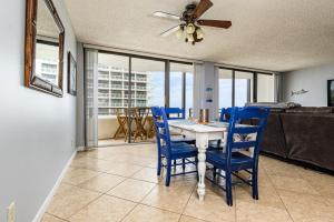 uma sala de jantar com uma mesa e cadeiras azuis em Glorious Ocean Sunset Views 2 Bed 2 Bath Condo em Daytona Beach
