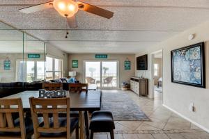 Un comedor y una sala de estar con mesa y sillas. en Oceanfront Sunrise 2 Bed 2 Bath Condo with Pool, en Ormond Beach