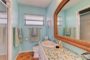 a bathroom with a sink and a mirror at Tipsy Turtle Direct Oceanfront in Palm Coast +33 photos