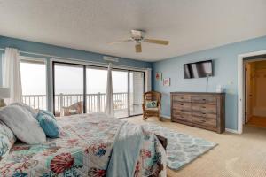a bedroom with a bed and a television and a balcony at Tipsy Turtle Direct Oceanfront in Palm Coast