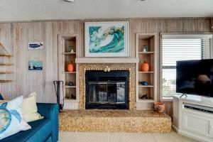 a living room with a blue couch and a fireplace at Tipsy Turtle Direct Oceanfront in Palm Coast