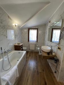 baño grande con bañera y lavamanos en L'albero Del Pepe, en Fiano Romano